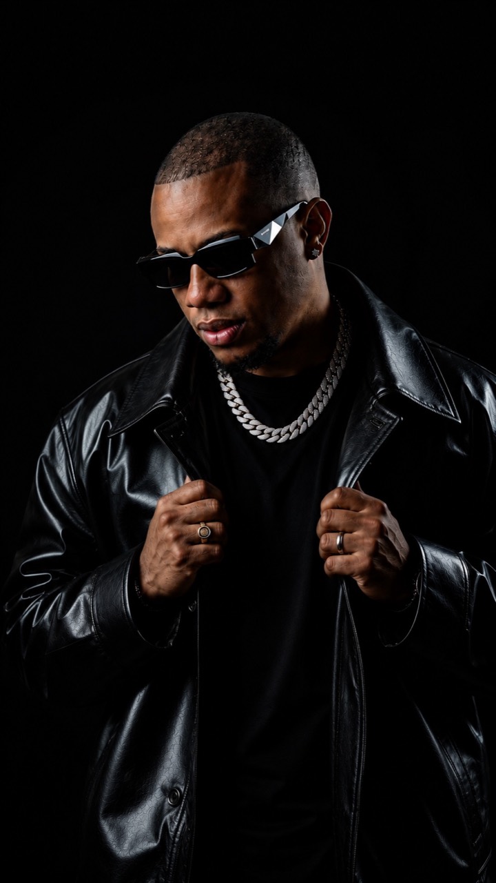 DJ Erick Familia — black studio portrait in leather jacket